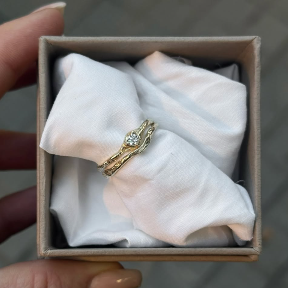 Gold ring with a diamond in a box on a white cloth